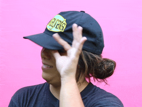 Video gif. A woman wearing a black baseball cap tilts the visor up slightly, half smiles with embarrassment or disgust, and rocks back slightly, rolling her eyes to the left in a look of disbelief. 