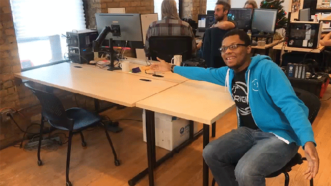 Charles motions to two empty desks at GlitchHQ