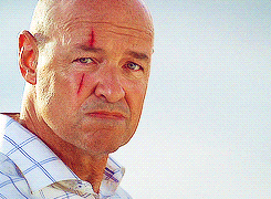 GIF of John Locke (Terry O'Quinn) who smiles to show that he has an orange peel inside his mouth.