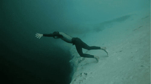 Gif of diver leaping off ledge and floating over the drop off of the continental shelf.