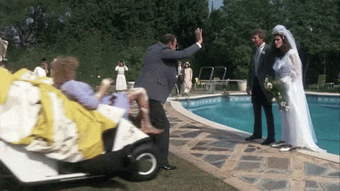 A man and woman stumble out of a golf cart, pushing a newlywed couple into a pool.