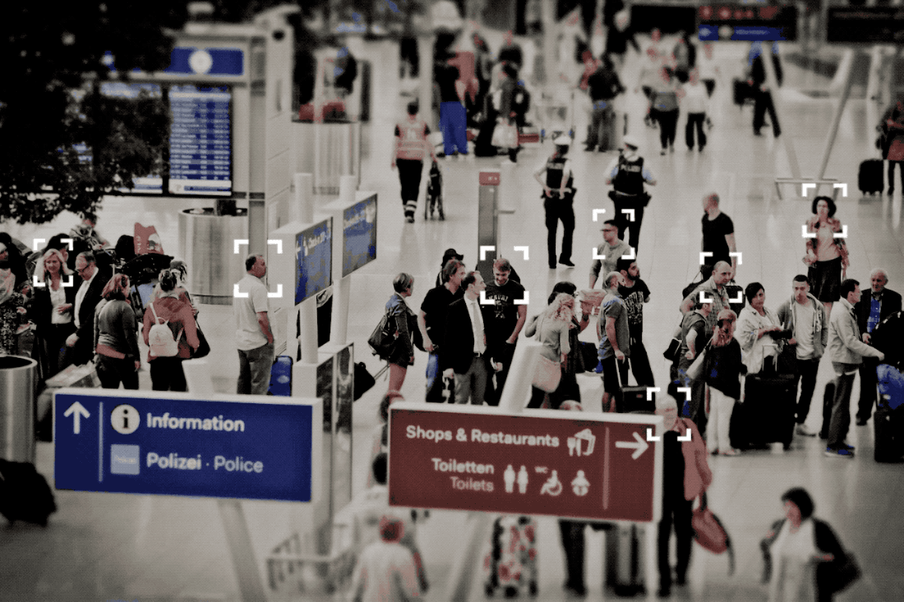 A GIF of a facial recognition system matching faces in a busy airport.
