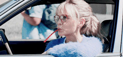 Carey Mulligan sitting in a car with a Twizzler in her mouth.