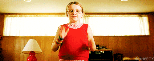 La protagonista del film Little Miss Sunshine nel suo body rosso si porta le mani al viso in un gesto di finto stupore