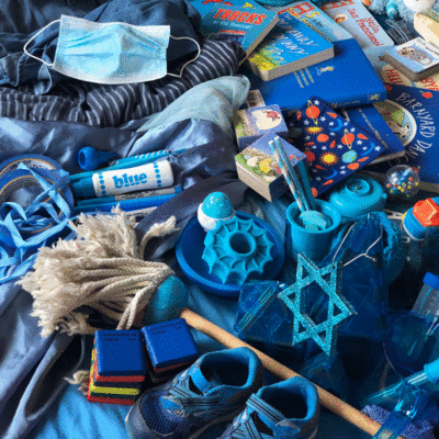 Year 5, Number Four, 33. Blue Blue. An animated loop panning over a pile of blue things: markers, shoes, toys, tupperware lids, plates, hats, water bottles, maps, books, clothes, etc.