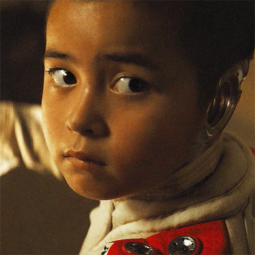 Animated gif from 2023 film The Creator. Madeleine Yuna Voyles as AI robot Alpha-O/Alphie turns her head
