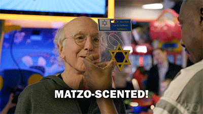 Gif of Larry David from Curb Your Enthusiam holding a Star of David Decal with the text, "Matzo-scented!"