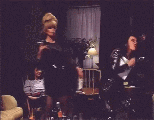 GIF shows Patsy and Edina from Ab Fab dancing in shiny black clothing while an unimpressed Saffy looks on