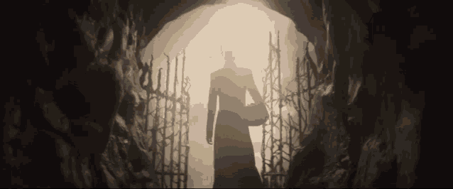a silhouette of a woman standing in a tunnel
