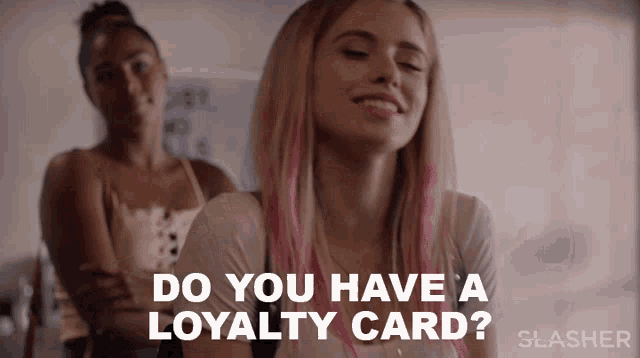 a woman with pink hair is smiling and asking if she has a loyalty card
