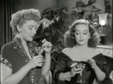 Gif from All About Eve featuring Bette Davis smoking and drinking a martini with another character
