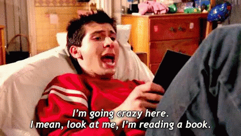Rhys from the TV show ‘Malcolm in the Middle’ reading a book on the couch and saying ‘I’m going crazy here. I mean, look at  me, I’m reading a book.’