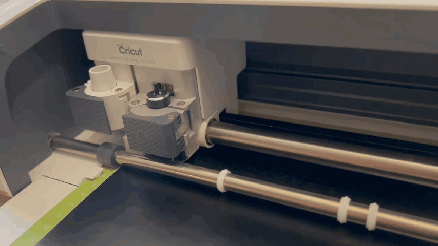 A Cricut machine cutting out paper.