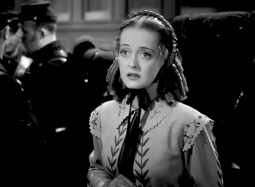 Animated gif feat. Bette Davis in a bonnet sighing and looking down in resignation