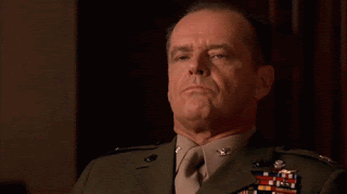 Jack Nicholson in full army uniform with a chest full of medal, is sitting in a court room in the dock. His expression looks pissed off and furious.