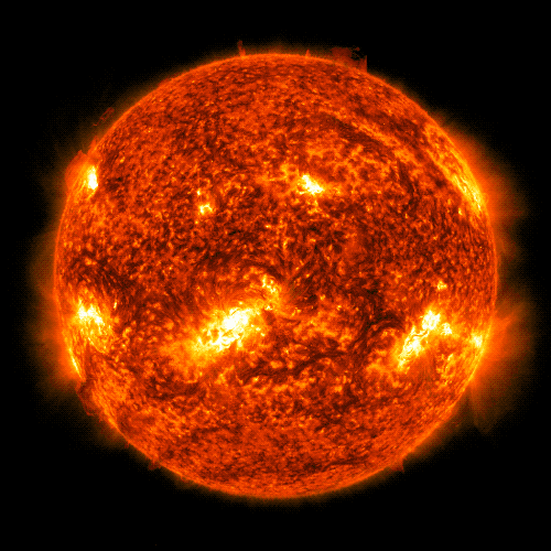 A red and gold Sun against a black background. A bright white and yellow X flashes and flickers in the upper left side of the Sun. This is the flare. The other parts of the Sun are mix of red and black.