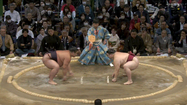 Grand Sumo: Shoannoumi (black) defeats Takanosho (red).