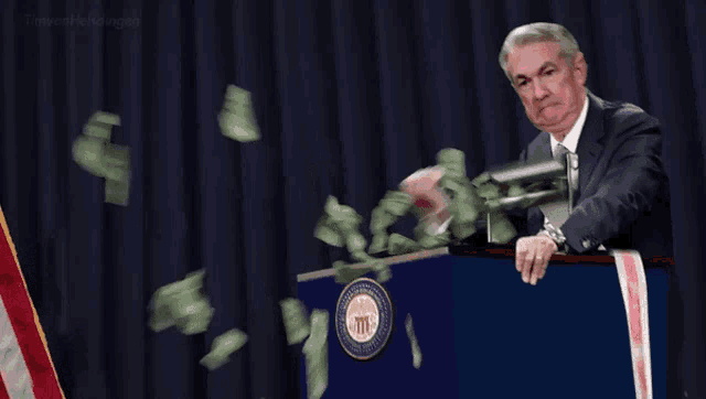 a man stands at a podium with a cnn inflation ribbon around his neck