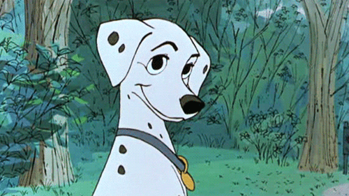 Disney gif. Perdita from 101 Dalmatians blinks slowly and smiles in a park.