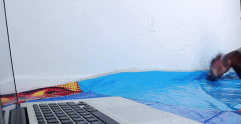 A guy slip and slides up to the computer and starts typing.