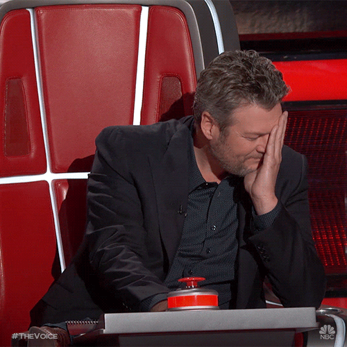 Gif of Blake Shelton on the Voice covering his face with his hand and trying not to laugh