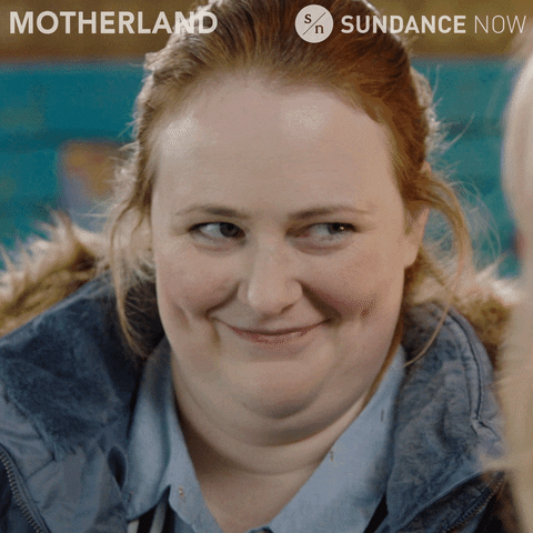 Anne from Motherland smiling and raising her eyebrows