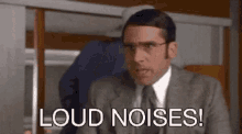 The man in a suit and tie has a funny face and says 