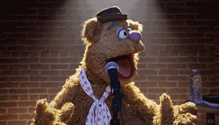 Gif dai Muppet con l'orso Fozzie pronto a fare stand up comedy davanti a un microfono, dondolando la testa da destra a sinistra e viceversa.