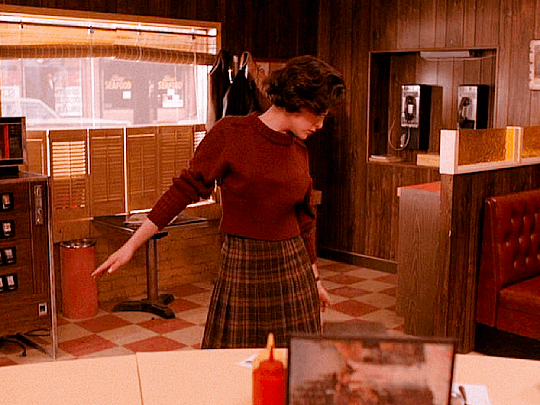 Audrey Horne, a character in the 90s TV show "Twin Peaks", dancing in an empty diner café.