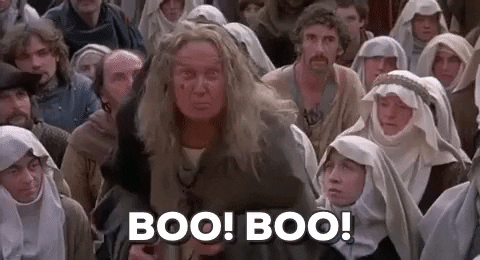 Movie gif. An ancient woman from the movie Princess Bride wears medieval peasant clothing beneath her long gray hair and bug eyes as she walks towards us yelling, "Boo! Boo!"