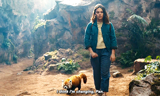 A teenage girl walks down the path between the rocks; a small red panda walks next to her. She says "I think I'm changing, Pan"