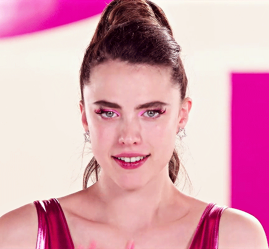 This may contain: a young woman with blue eyes and pink makeup looks at the camera while wearing a red dress
