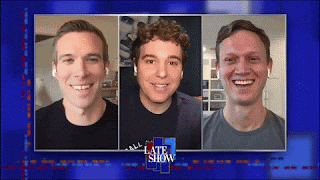 A three-way split zoom screen showing the three of the hosts of Pod Save America. Jon Favreau, Jon Lovett, and Tommy Vietnor. They're all smiling and laughing at something that's been said on the other side of the conversation.