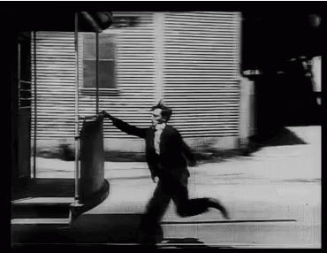 a man in a suit and tie is running across a street (Provided by Tenor)