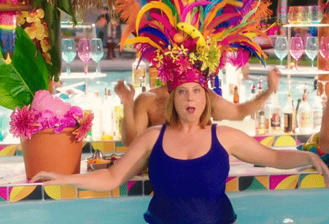 happy crazy ex girlfriend GIF of woman in a pool shimmying while wearing an enormous feathered headdress as the word 'bah' appears around her for no apparent reason