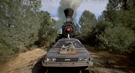 Gif da "Ritorno al futuro III" con la locomotiva che spinge sui binari la DeLorean, mentre tutto attorno scorre il paesaggio di alberi. Locomotiva e DeLorean si stanno muovendo verso chi guarda la foto.