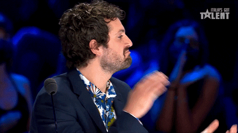 Reality TV gif. Frank Matano as a judge on Italia's Got Talent looks convinced, his chin in a thoughtful frown as he claps.