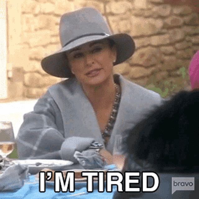 a woman wearing a hat says i 'm tired