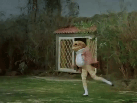 GIF of a ballet dancer dressed as a frog and doing joyful jetés next to a pond