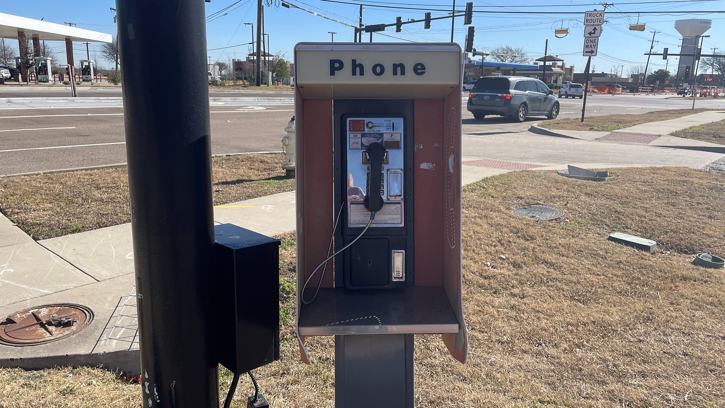A payphone next to a busy road