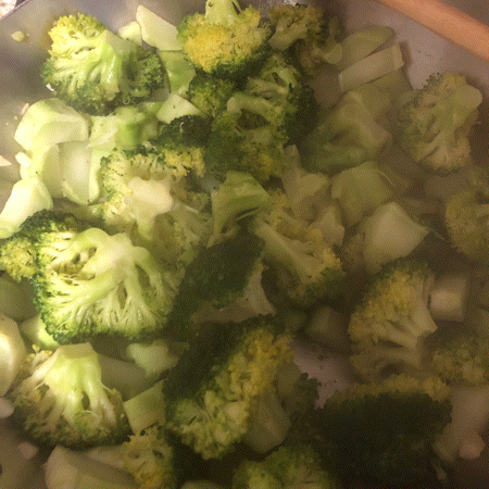 An animated photo loop of a pan of broccoli and a pot of pumpkin soup on the stove, first the broccoli, then then the soup, then both. 