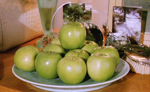 imagem de um prato cheio de maçãs verdes brilhantes