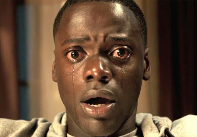 Cena de "Corra!". Close-up de um jovem negro de olhos arregalados, lágrimas escorrendo por seus olhos.