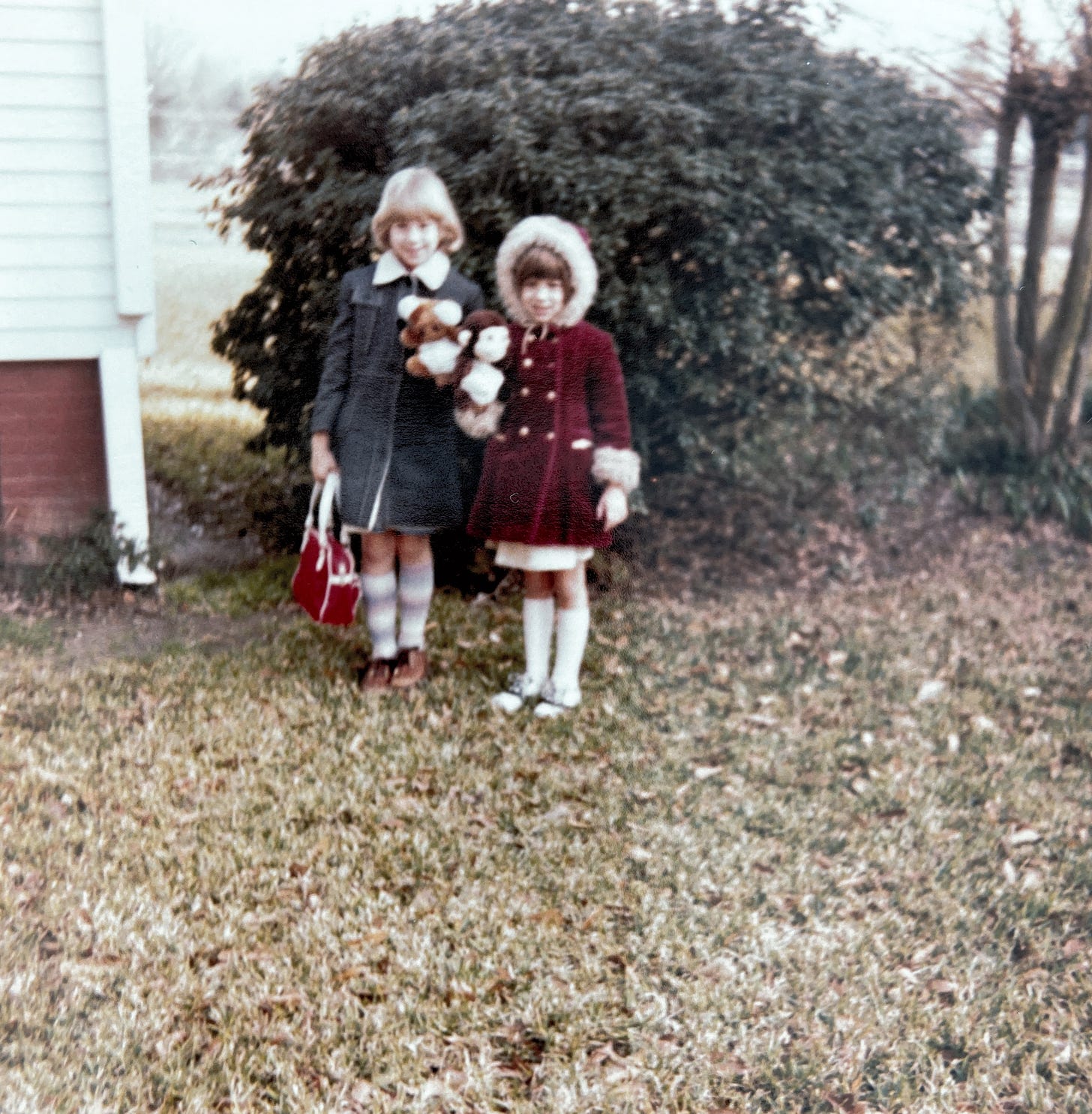 two girls standing outside in coats