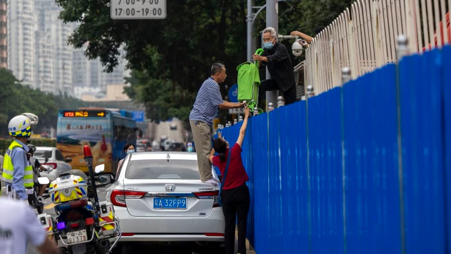 GUANGZHOU, CHINA - NOVEMBER 17 2022: A couple pass necessities to a relative over the fence encircling a Covid-19 lockdown zone in Guangzhou in south China's Guangdong province Thursday, Nov. 17, 2022. (Photo credit should read JULIEN TAN / Feature China/Future Publishing via Getty Images)