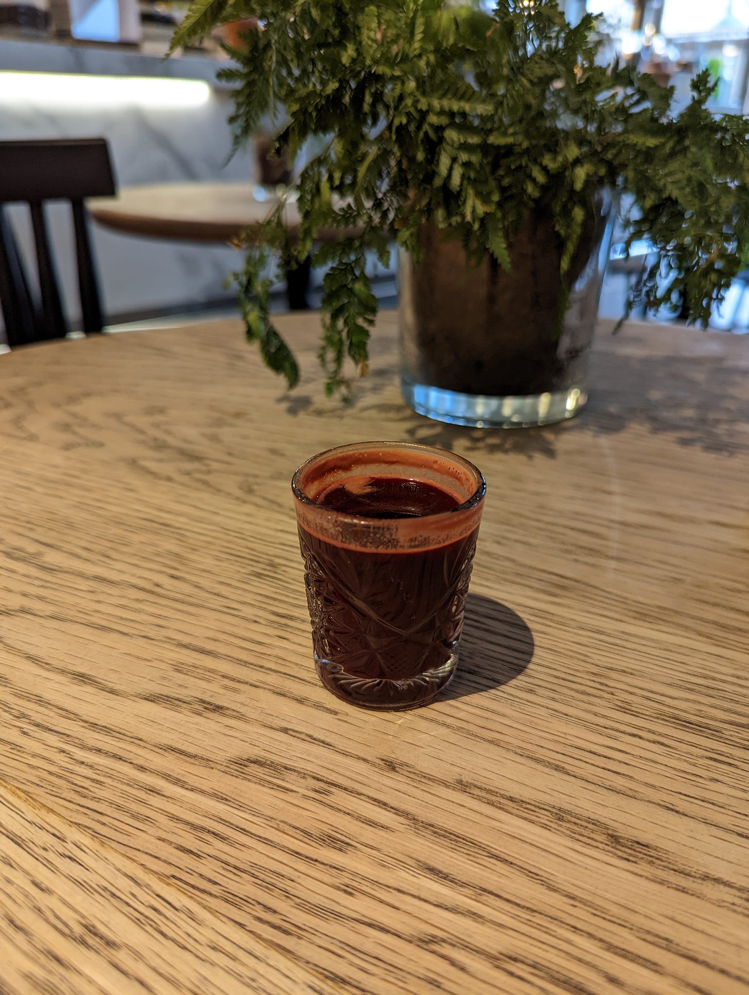 Espresso glass containing coffee and beetroot juice
