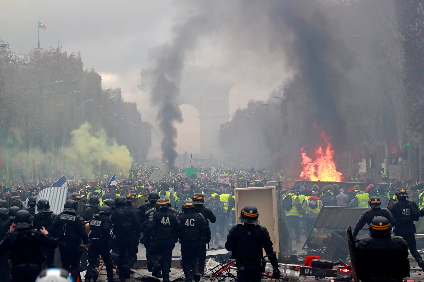 Protesters wearing yellow vests, a symbol of a French drivers' protest against higher fuel prices, run from police during riots on the Champs-Elysees in Paris, France, November 24, 2018. REUTERS/Gonzalo Fuentes