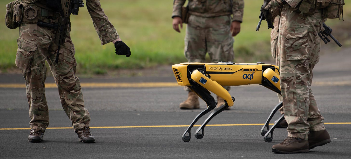 A Boston Dynamcis robot dog Spot walks amongst some soldiers in the UK