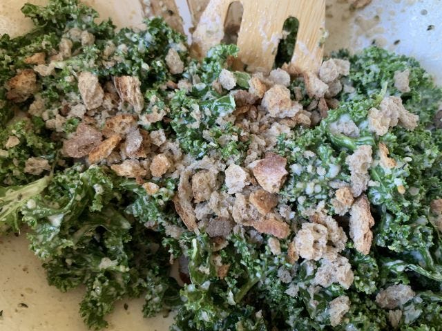 A green salad with bits of bread
