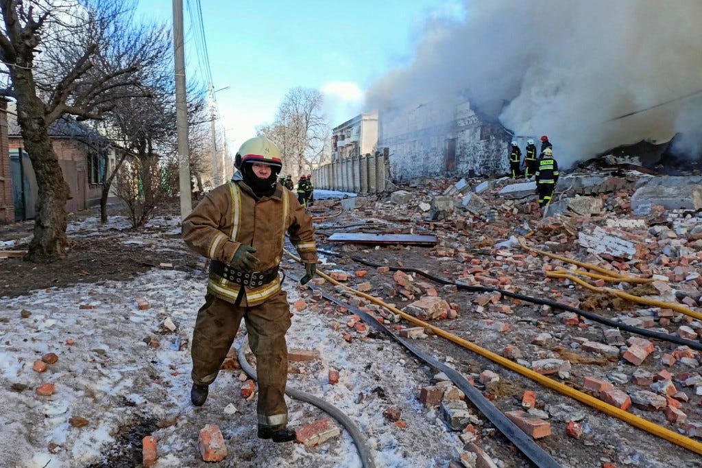 Rescuers work at a site of a warehouse storing products burned after shelling,